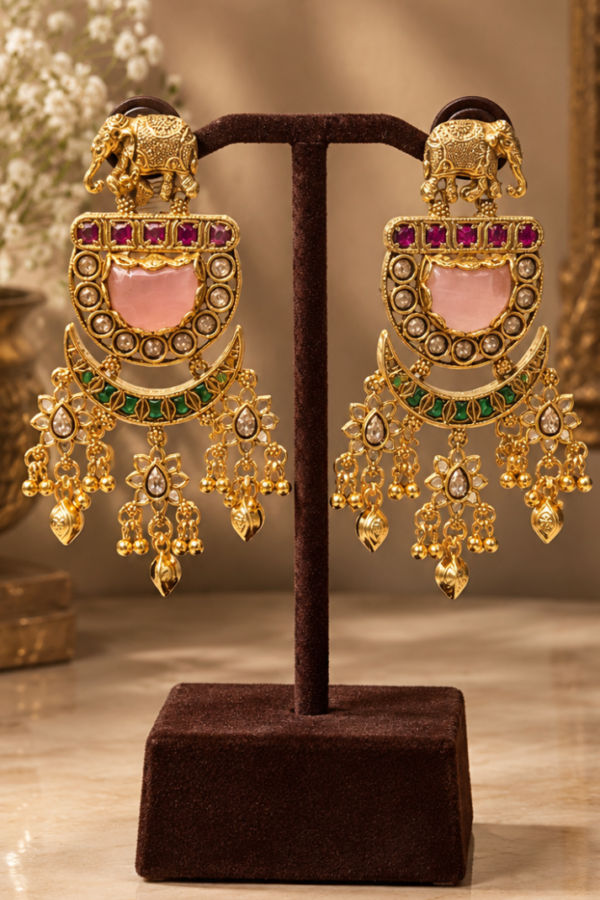Women's Gold-Tone Traditional Kundan-Style Chandbali Dangle Earrings with Pink and Green Stone Detailing## Product Name  Women's Gold-Tone Traditional Kundan-Style Chandbali Dangle Earrings with Pink and Green Stone Detailing  ## Product Specifications  | Attribute       | Specification                                                | | --------------- | ------------------------------------------------------------ | | Product Type    | Women's Traditional Drop Earrings                            | | Color           | Gold-Tone with Pink, Green, and White Accents                | | Pattern         | Traditional Ornamental Design                                | | Style           | Ethnic / Festive / Traditional                               | | Design          | Elephant Motif with Crescent-Shaped Chandbali Design         | | Stone Detailing | Pink, Green, and White Stone-Like Details Visible            | | Earring Type    | Long Dangle Earrings                                         | | Shape           | Crescent / Chandbali                                         | | Embellishment   | Decorative Stones and Intricate Gold-Tone Detailing          | | Quantity        | 1 Pair                                                       | | Occasion        | Festive, Wedding, Partywear, and Traditional Occasions       | | Size & Fit      | Long, Statement-Style Design; Exact Dimensions Not Available | | Closure Type    | Not Clearly Visible                                          | | Brand           | Not Specified                                                | | Material        | Cannot Be Confirmed from Image                               |